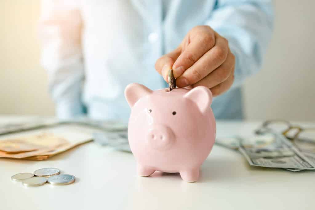 woman putting money coin in piggy bank for saving money and plan finance.