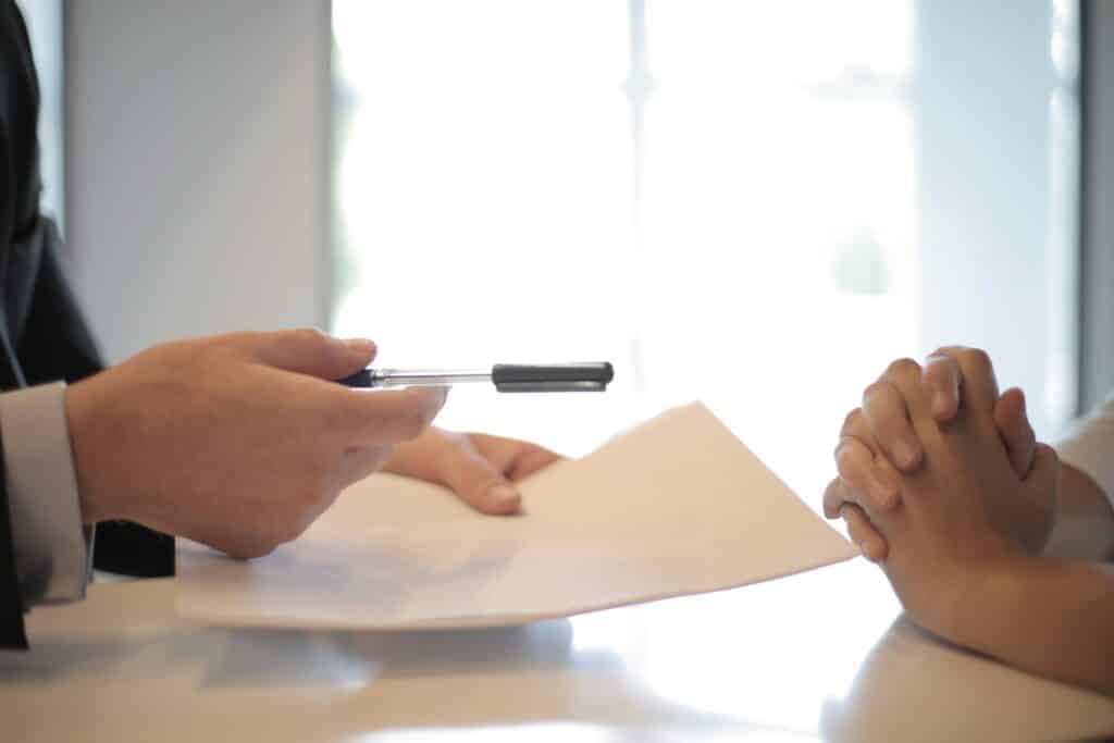 a businessman handing a contract to a person